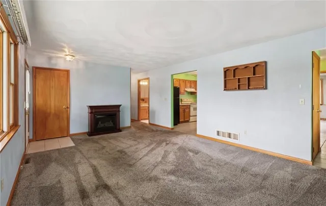 a view of an empty room with window and fireplace