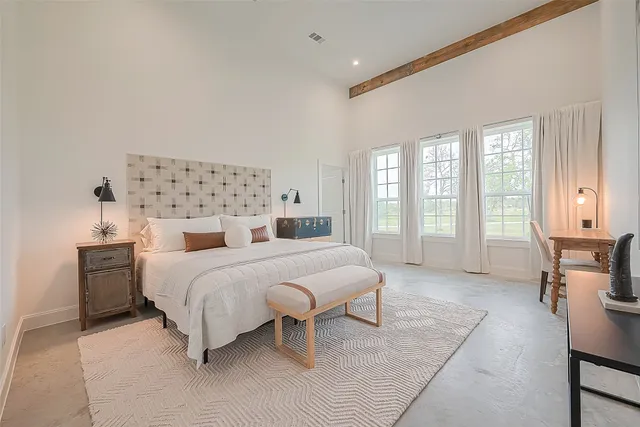 a spacious bedroom with a bed and a table