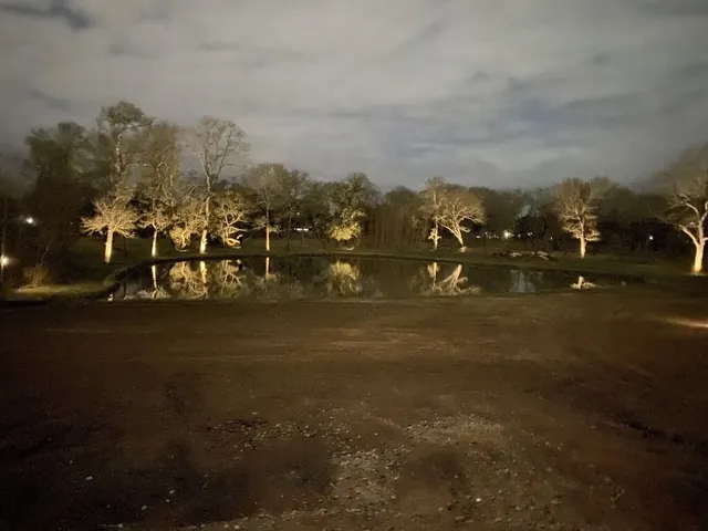 a view of a lake with a big yard and large trees