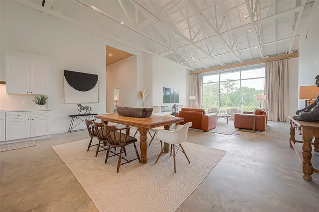 a living room with furniture a large window and a dining table