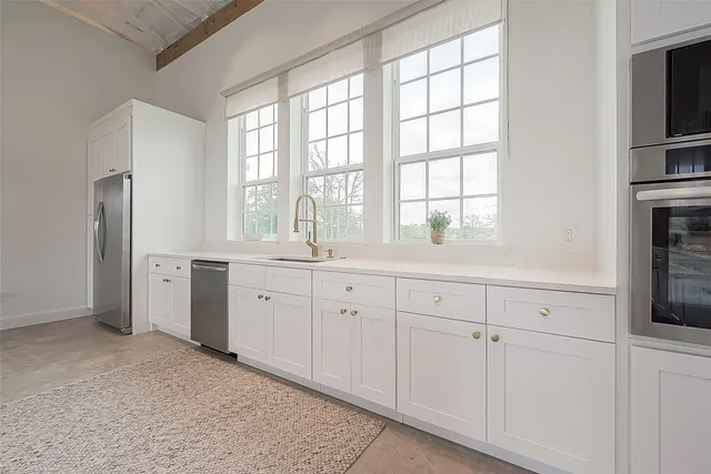 a kitchen with white cabinets and white appliances
