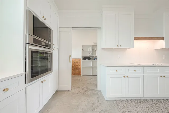 a large white kitchen with a large window