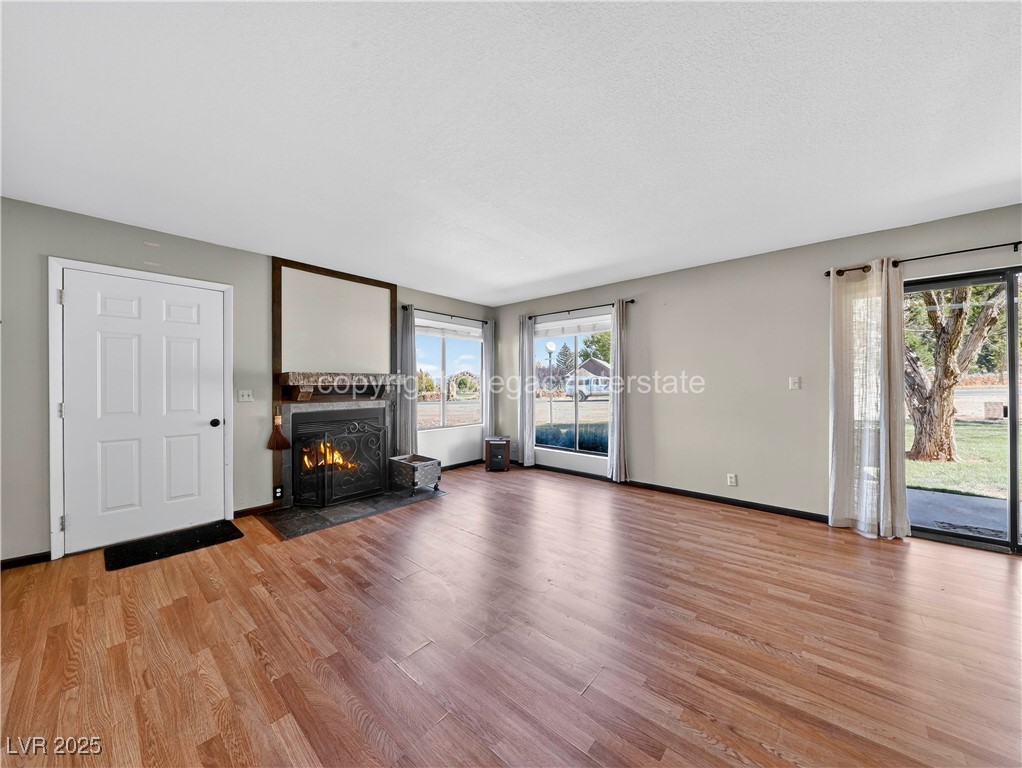 390 East 300 South, Unit 3A Parowan, UT 84761 - Photo 6 of 25 Unfurnished living room with light wood finished floors and a fireplace with flush hearth