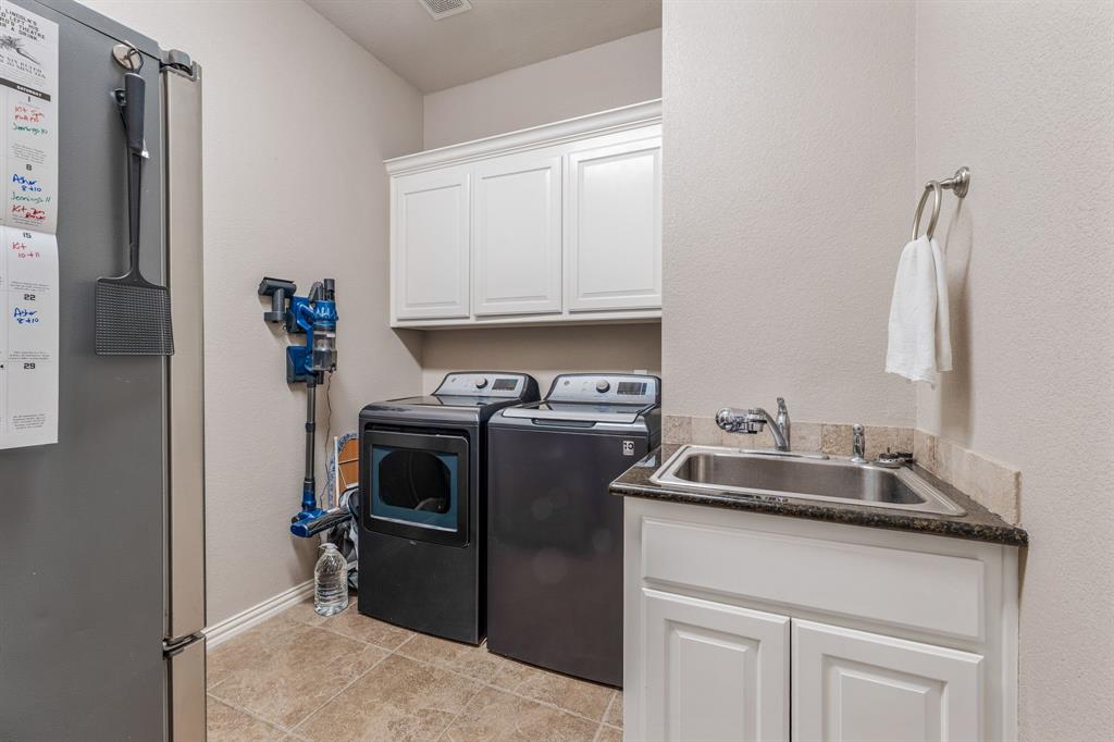 2936 Willow Ridge Circle Granbury, TX 76049 - Photo 15 of 33 a kitchen with a sink and a refrigerator