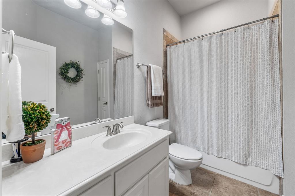 2936 Willow Ridge Circle Granbury, TX 76049 - Photo 17 of 33 a bathroom with a sink a toilet and shower curtain