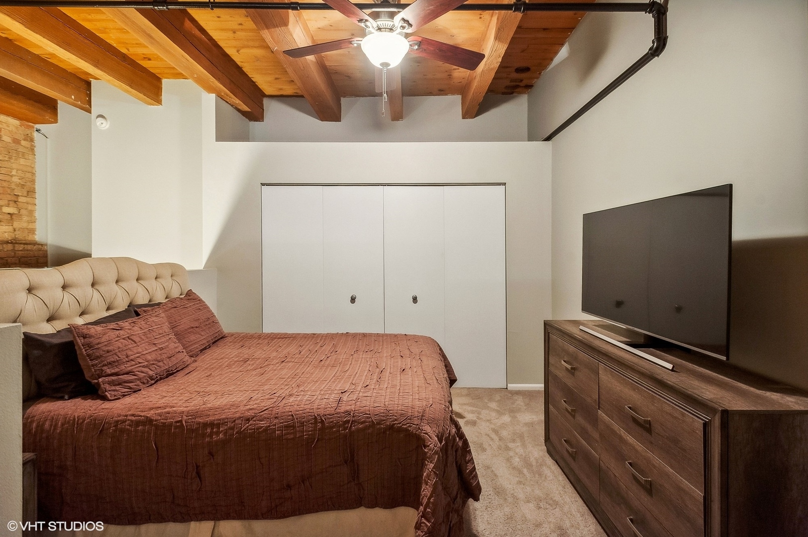 1733 West Irving Park Road, Unit 214 Chicago, IL 60613 - Photo 14 of 20 a bedroom with a bed and a flat screen tv