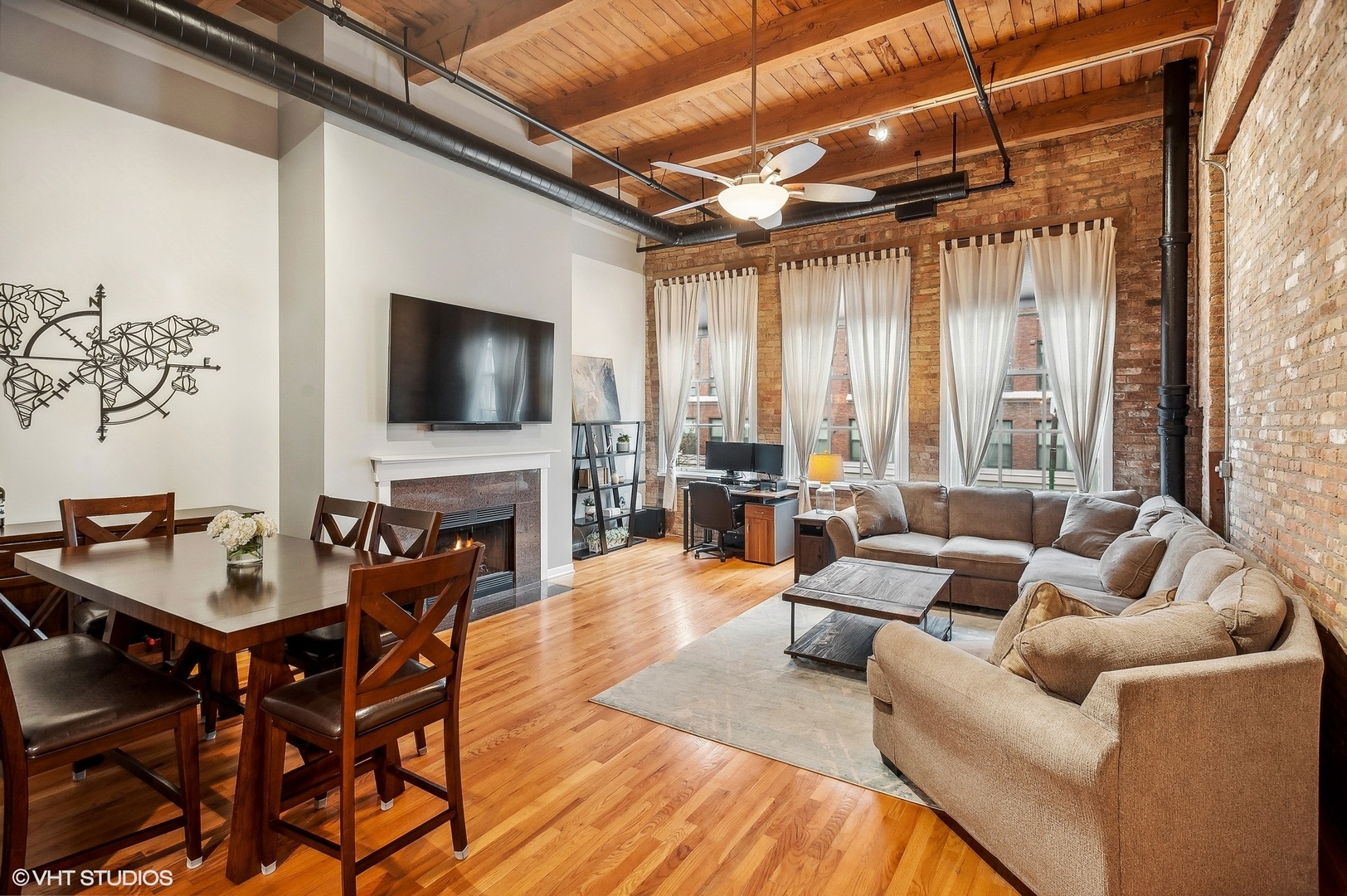 1733 West Irving Park Road, Unit 214 Chicago, IL 60613 - Photo 2 of 20 a living room with furniture a fireplace and a flat screen tv