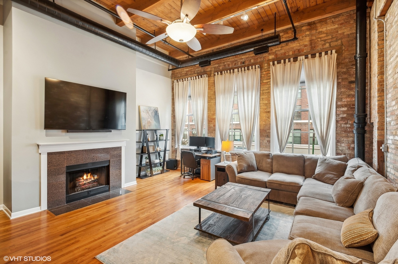 1733 West Irving Park Road, Unit 214 Chicago, IL 60613 - Photo 5 of 20 a living room with furniture a fireplace and a flat screen tv