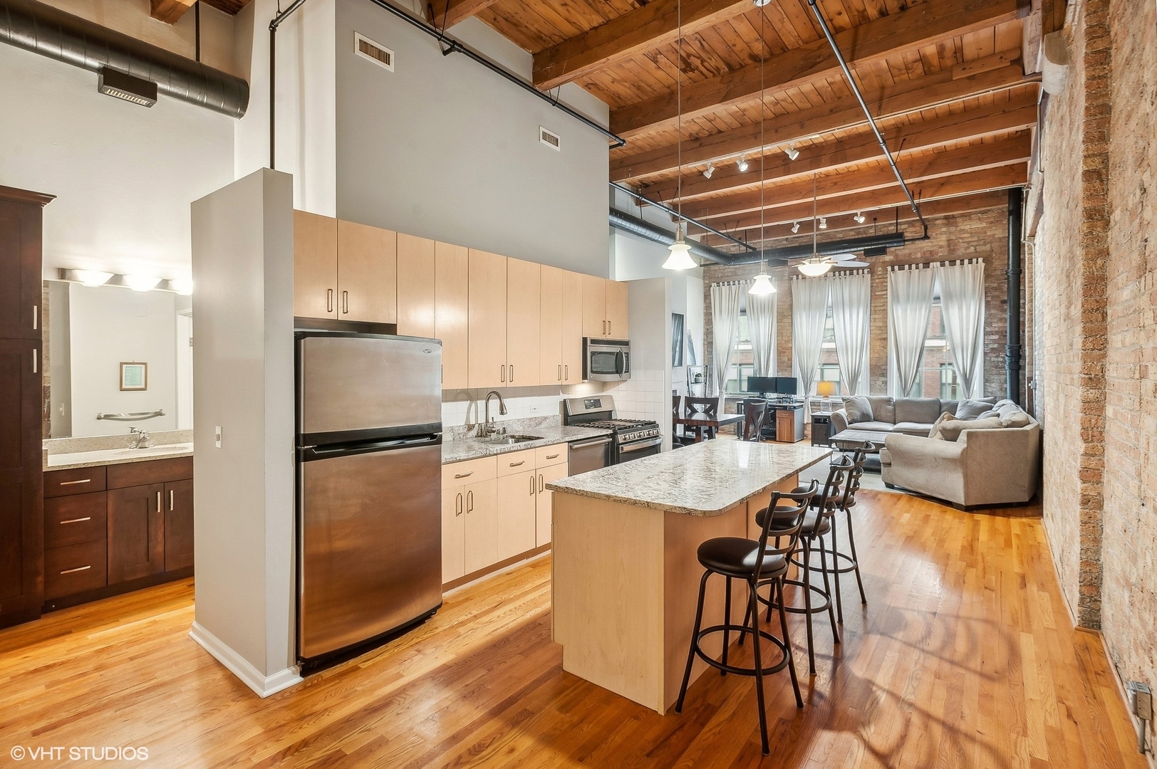 1733 West Irving Park Road, Unit 214 Chicago, IL 60613 - Photo 7 of 20 a kitchen with stainless steel appliances a refrigerator a sink dishwasher a stove and white cabinets with wooden floor