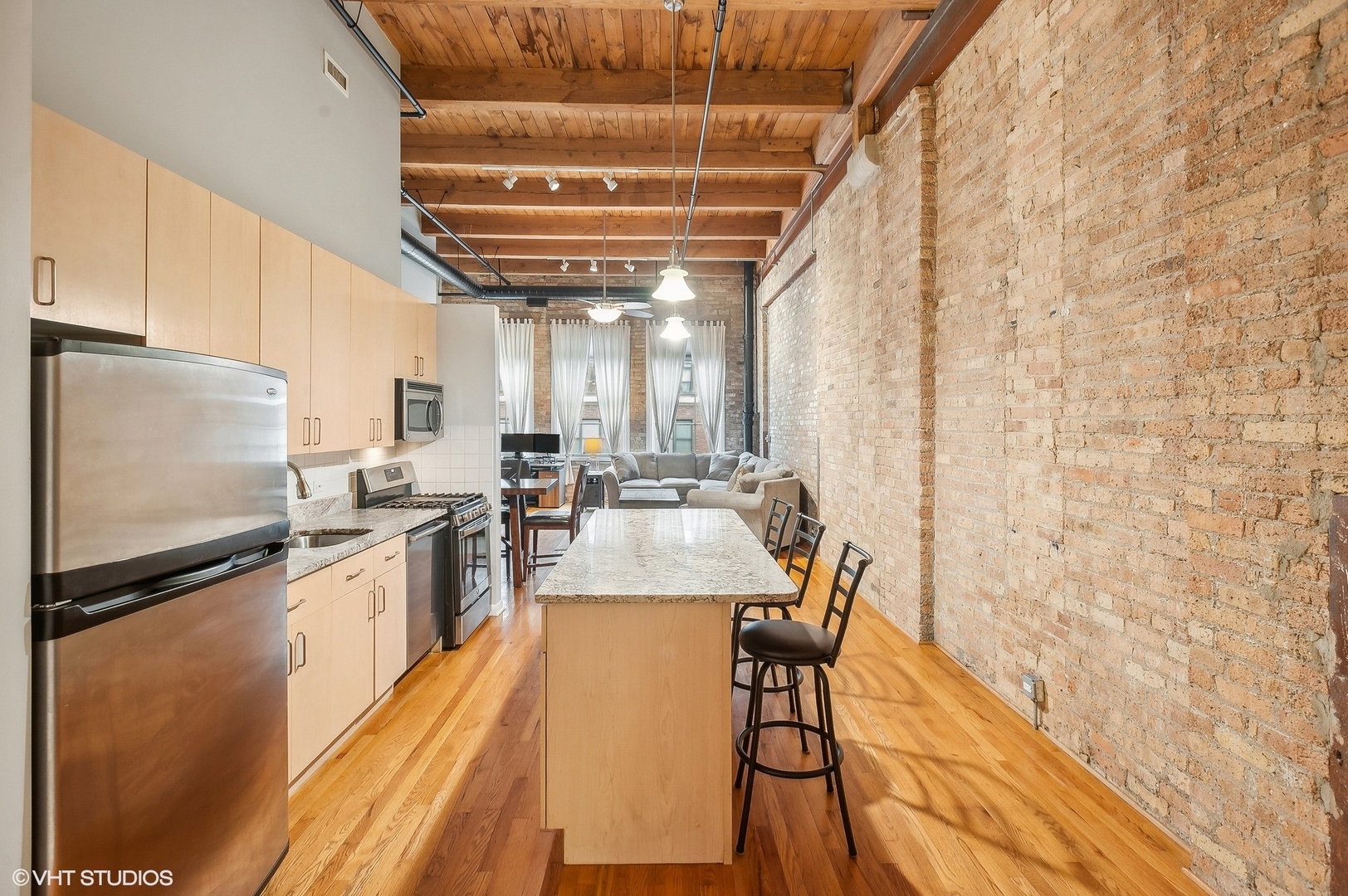 1733 West Irving Park Road, Unit 214 Chicago, IL 60613 - Photo 8 of 20 a kitchen with stainless steel appliances granite countertop a sink a stove top oven a chimney and a refrigerator