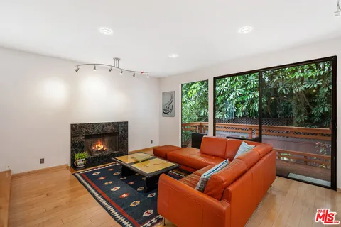 a living room with furniture fireplace and a large window