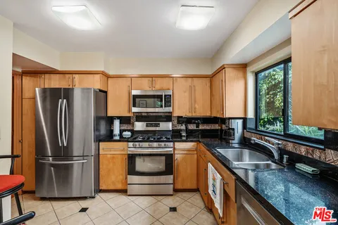 a kitchen with a refrigerator sink and stove top oven