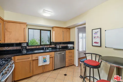 a kitchen with granite countertop a sink and a stove