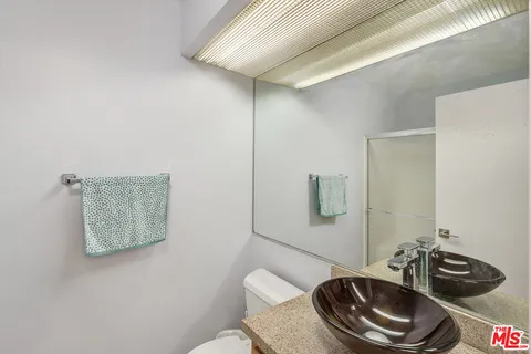 a bathroom with a toilet a sink and mirror