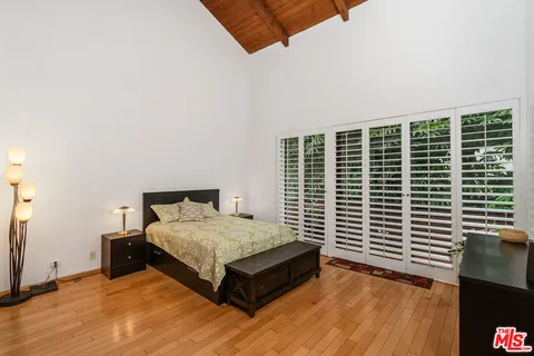 a bedroom with a bed and a large window