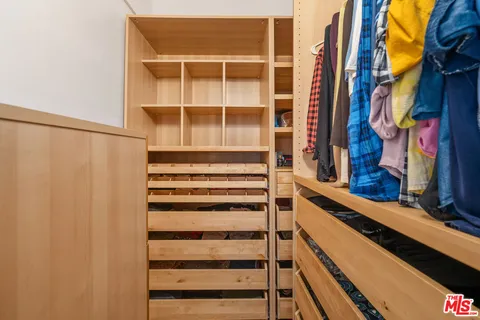 a view of walk in closet with empty racks