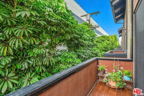 a view of a balcony with flower plants