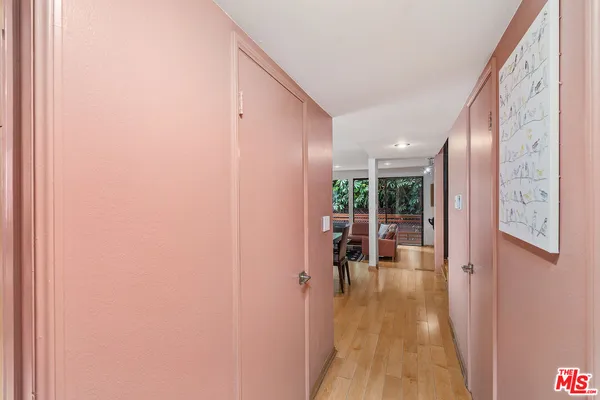 a view of a hallway with wooden floor and furniture