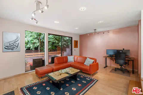 a living room with furniture floor to ceiling window and a table