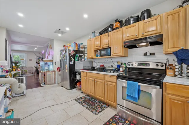 a kitchen with stainless steel appliances granite countertop a stove top oven a sink dishwasher and cabinets with wooden floor