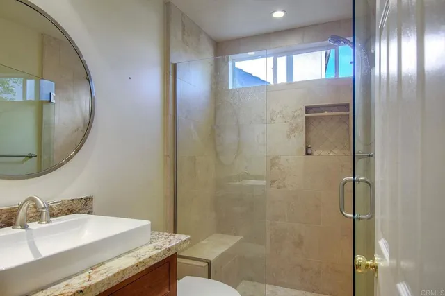 a bathroom with a granite countertop sink toilet and shower