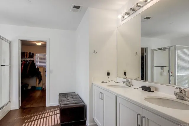 a en suite bathroom with a double vanity sink and a mirror