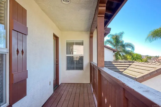 a view of a balcony with wooden floor and fence