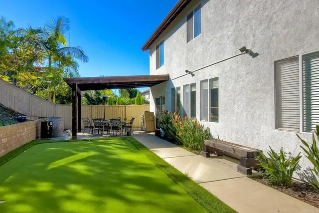 a view of a house with backyard and sitting area