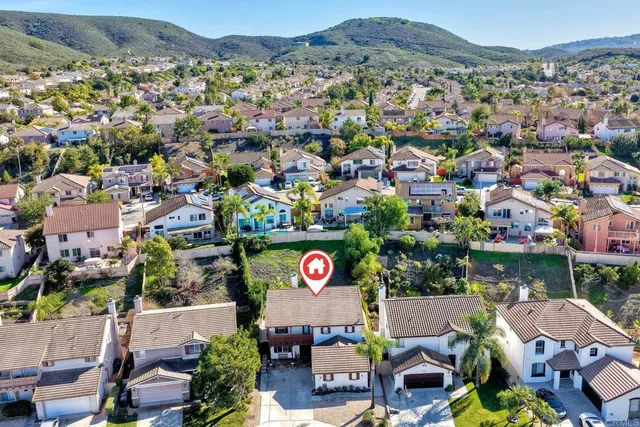 an aerial view of a city with lots of residential buildings ocean and mountain view in back