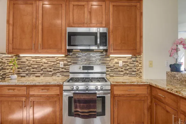 a kitchen with granite countertop cabinets stainless steel appliances and a sink
