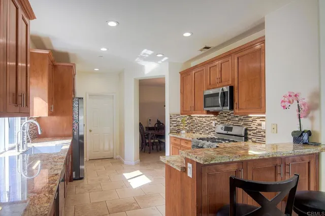 a kitchen with kitchen island granite countertop a stove and a refrigerator