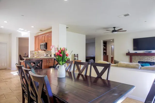 a view of a dining room with furniture a rug and wooden floor