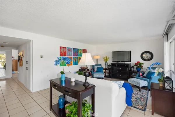 a living room with furniture a flat screen tv and a window