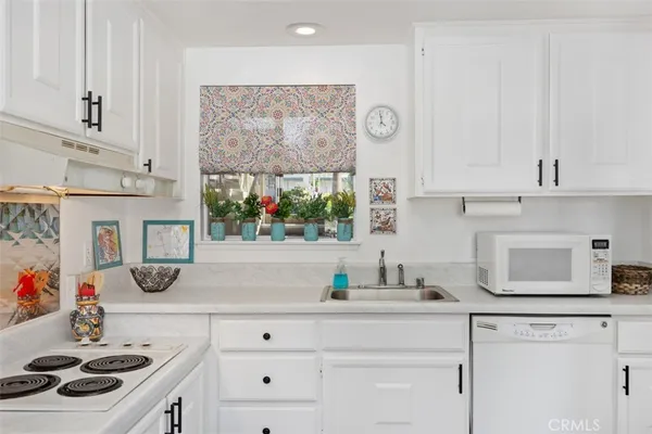 a kitchen with white cabinets and white appliances
