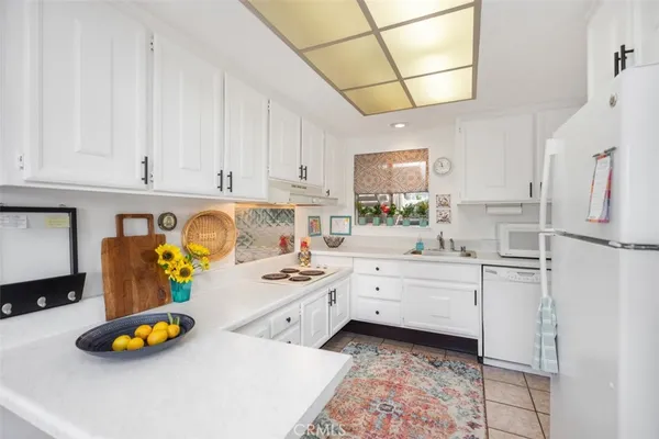 a kitchen with stainless steel appliances granite countertop a sink a stove and white cabinets
