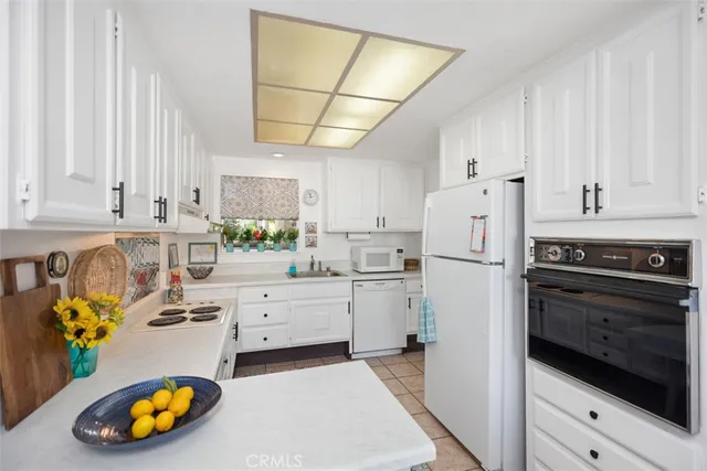 a kitchen with stainless steel appliances a refrigerator sink cabinets and wooden floor
