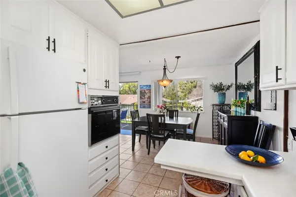 a kitchen with stainless steel appliances a stove a refrigerator and a dining table