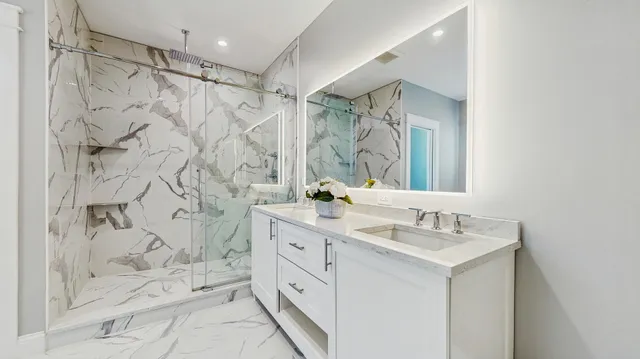 a bathroom with a double vanity sink mirror and shower