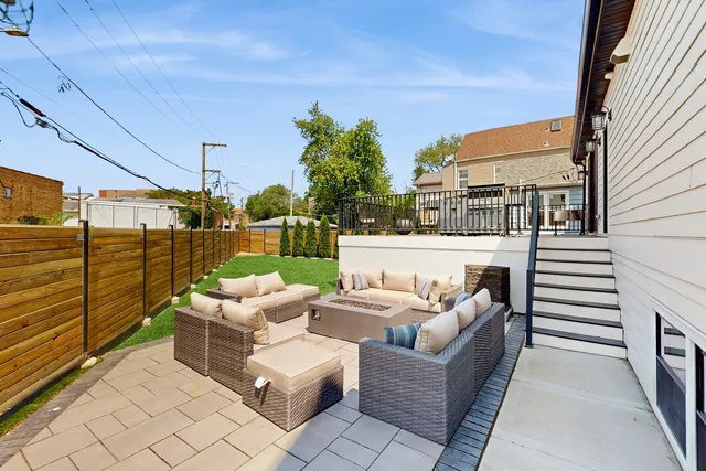 a view of a patio with couches chairs potted plants and wooden floor