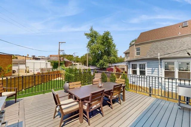 a view of a roof deck with table and chairs with wooden floor