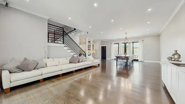 a living room with furniture and kitchen view with wooden floor