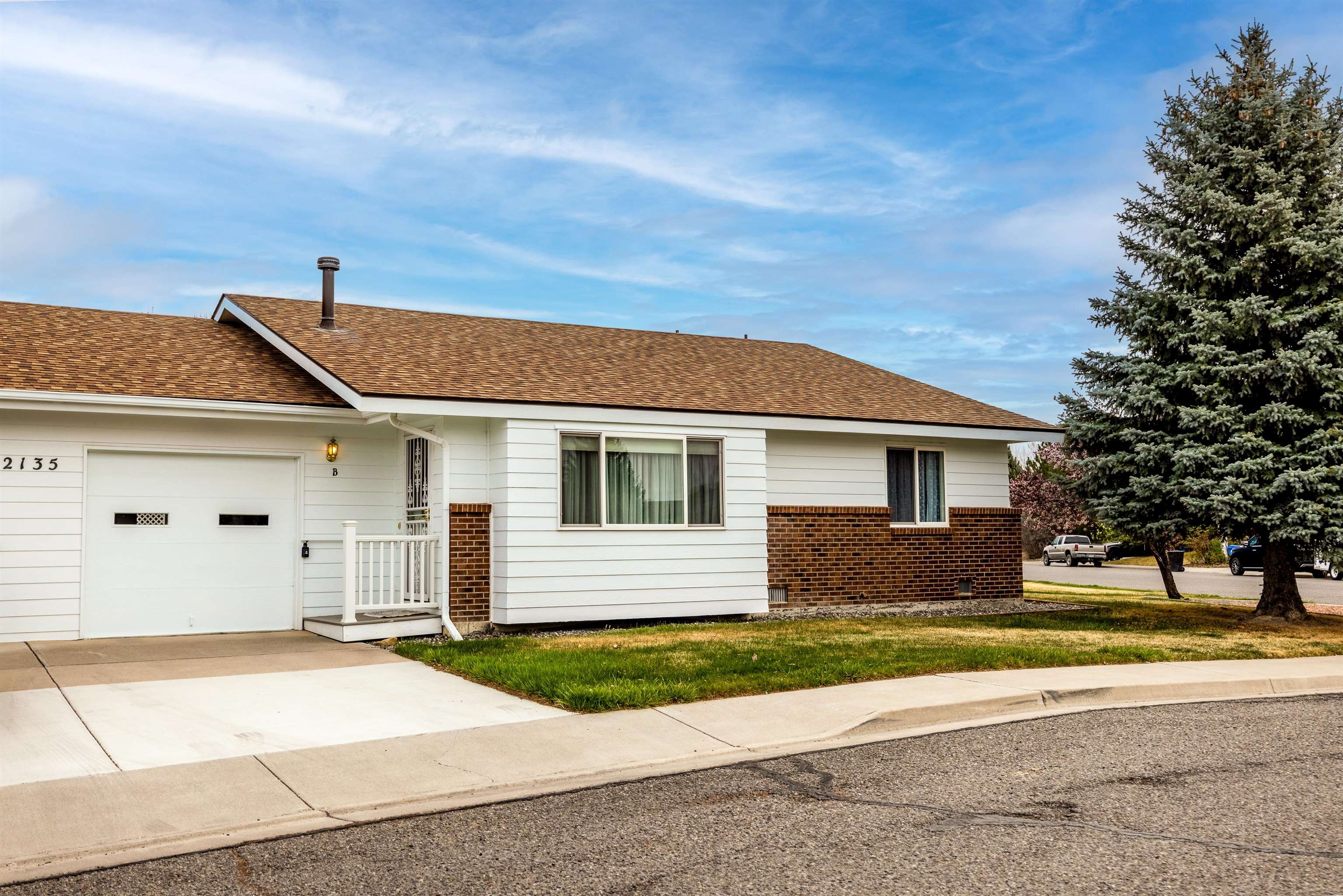 2135 Winston Way, Unit B Montrose, CO 81401 - Photo 1 of 25 a front view of a house with a yard and garage