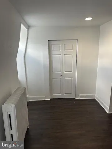 an empty room with wooden floor and mirror