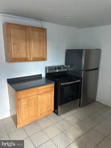 a kitchen with granite countertop a refrigerator and a stove top oven