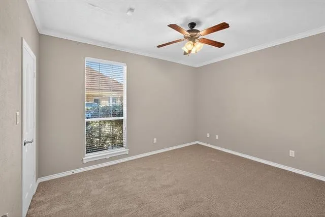 an empty room with ceiling fan and windows