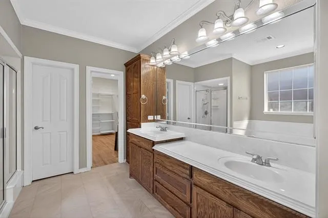a spacious bathroom with a double vanity sink a mirror and a shower