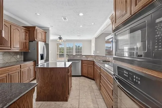 a kitchen with stainless steel appliances granite countertop a stove a sink dishwasher a refrigerator and cabinets with wooden floor