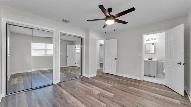 a view of a livingroom with wooden floor and a ceiling fan