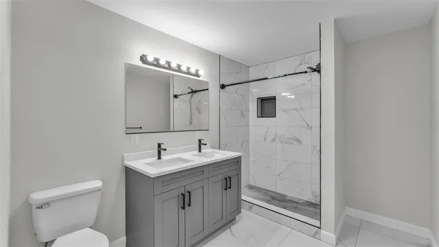 a bathroom with a shower sink and mirror