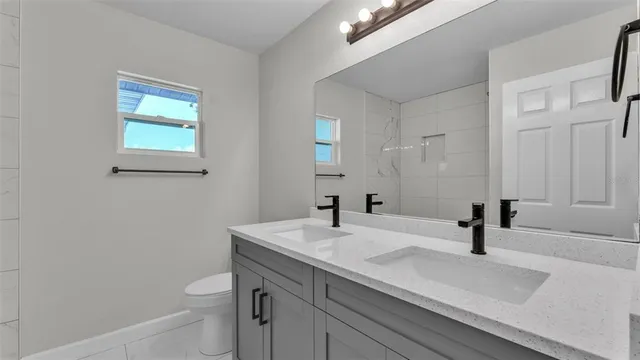 a bathroom with a sink a toilet and a mirror